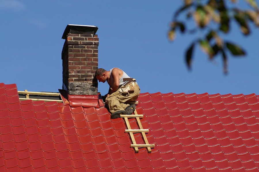 a man repairing the red  roof